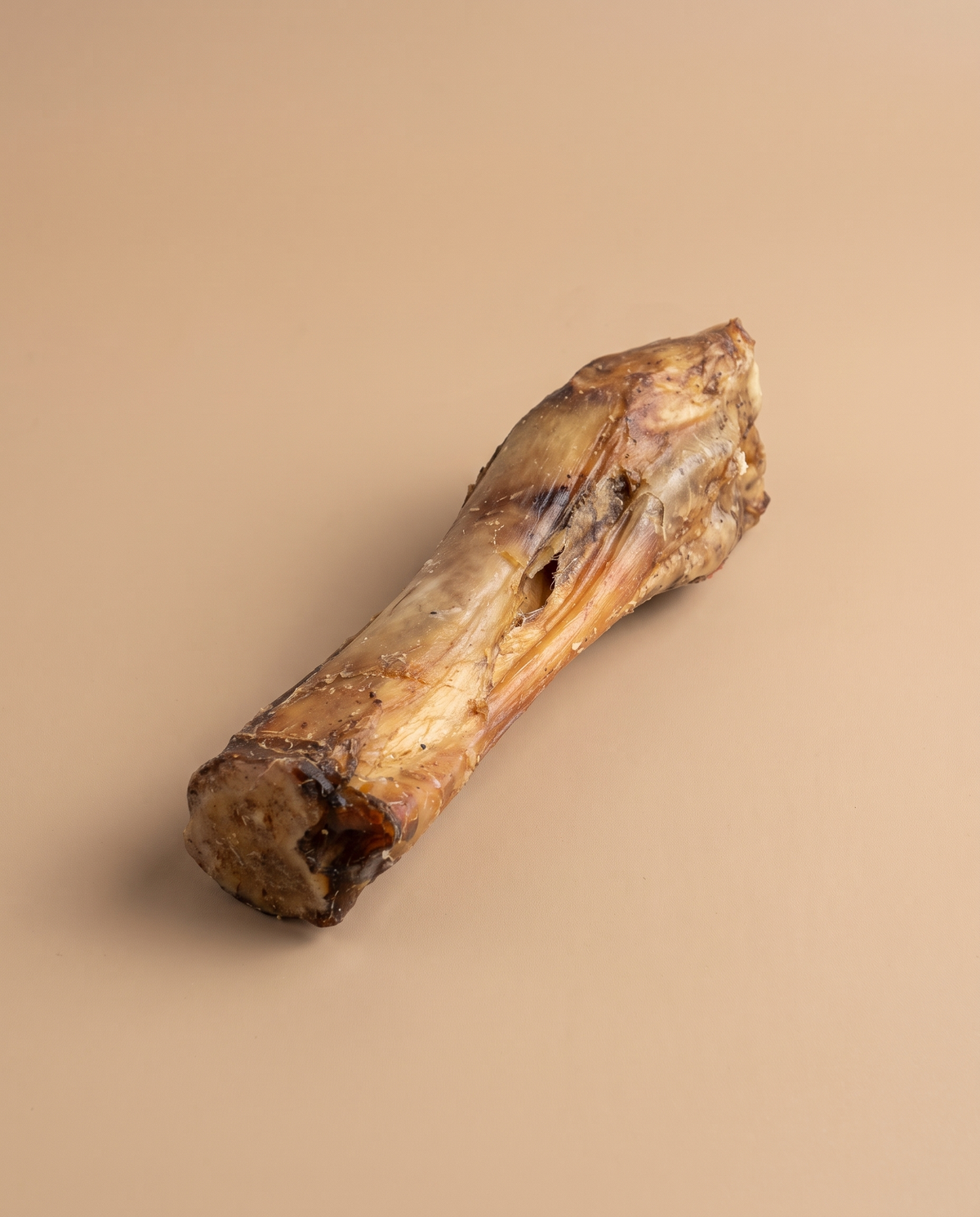 Sfeerfoto: kalfspoot kauwsnack tegen een beige studioachtergrond