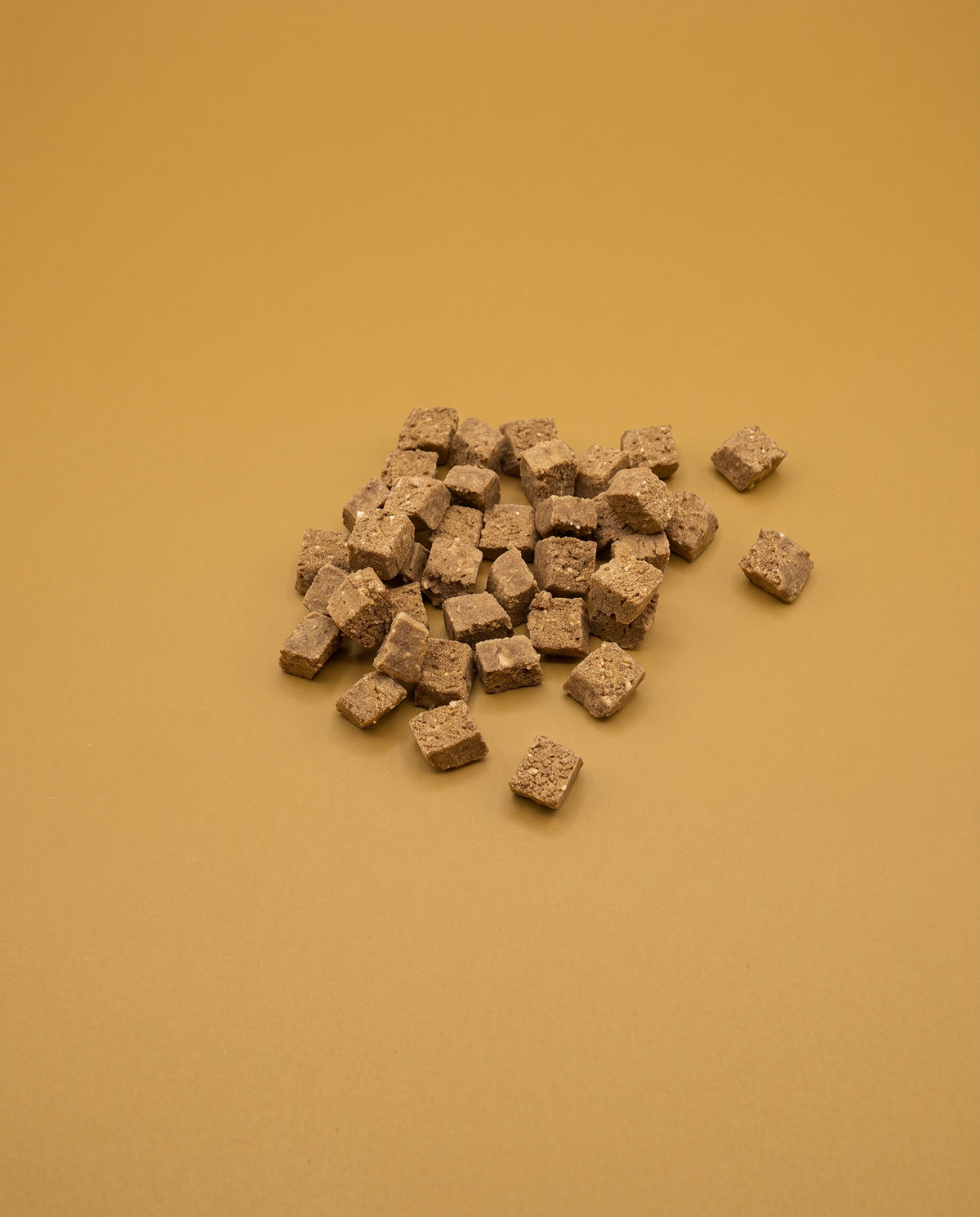 Sfeerfoto: kleine hoeveelheid trainers met pens (200 gram), tegen een mosterdgele studioachtergrond