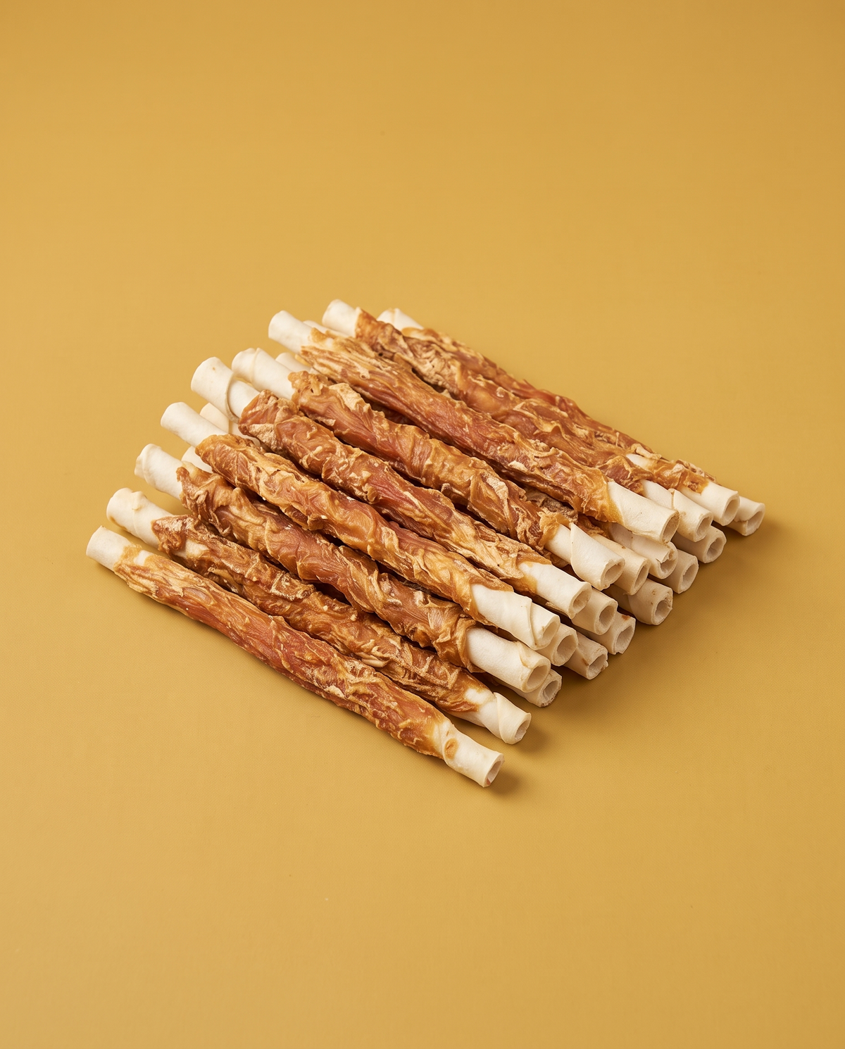 Sfeerfoto: hoop rawhide strips met kip (20CM, 20 stuks), tegen een mosterdgele studioachtergrond